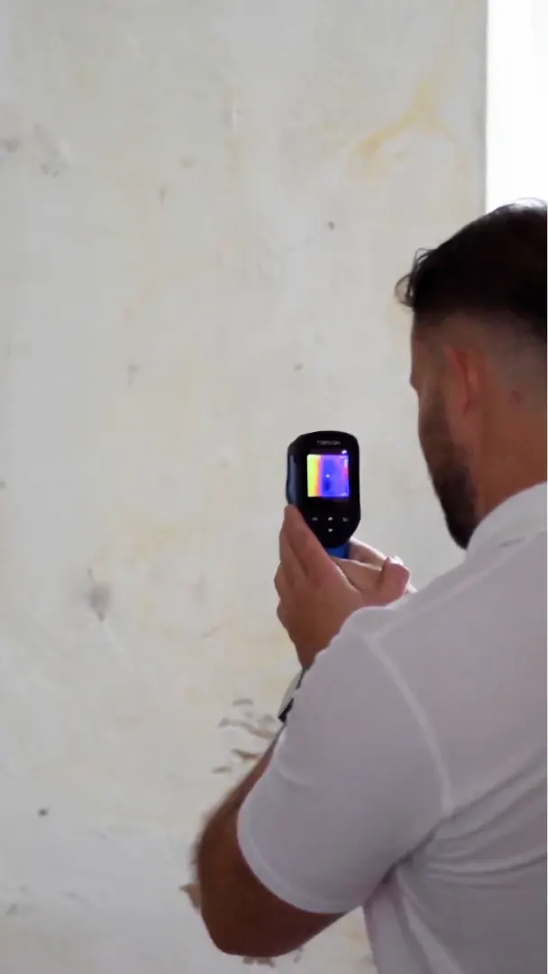 CRS Energy surveyor using a thermal camera to inspect a wall with poorly installed cavity insulation